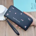 Black long zipper wallet with floral embroidery and wrist strap for stylish women. - Black