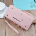 Pink long women wallet with floral embroidery, zipper closure and wrist strap design. - Pink