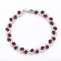 Elegant silver tennis bracelet featuring cross-set red stones and sparkling cubic zirconia. - Silver and Red
