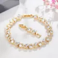 Gold tone rhinestone S-curve bracelet close-up view showing sparkling cubic zirconia. - Gold + White