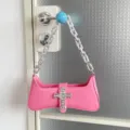 Rosa Schultertasche mit klobiger Silberkette und Strasskreuz-Anhänger, trendiger Punk-Stil. - Rosa