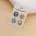 Vista dettagliata di quattro spille magnetiche con strass per hijab in varie finiture su carta. - Set di 4 Colori