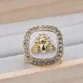Dettaglio dell'anello per sciarpa quadrato con ape e strass brillanti su base a quadri. - Bianco