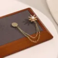 Gedetailleerde opname van de elegante gouden madeliefje magneetbroche met sprankelende steentjes en parel. - Madeliefje