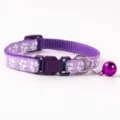 Purple pet collar detail, featuring cute white paw print pattern and a shiny metal bell. - Paw Print Style / Purple