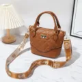 Brown quilted crossbody handbag with top handles and branded guitar strap for women daily use. - Yellow Brown