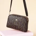 Brown monogram crossbody bag with dual compartments, adjustable strap and front buckle design. - Small Letter