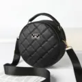 Black round quilted crossbody bag with top handle and adjustable strap for women main - Black