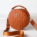 Stylish brown round quilted crossbody bag with top handle and wide strap for women. - Brown