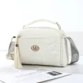 Stylish white quilted crossbody bag for women, featuring top handle and elegant tassel decor. - Off White