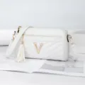 White quilted crossbody shoulder bag with golden V logo and cute tassel pendant accessory. - White