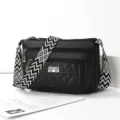 Black multi-pocket shoulder crossbody bag with wide patterned strap and quilted detail. - Black