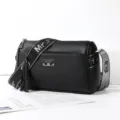 Stylish black PU leather pillow shoulder bag for women, featuring a wide strap and tassel. - Metal Tag Style / Black
