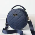 Dark blue round quilted crossbody bag with top handle and stylish heart embroidery design. - Blue