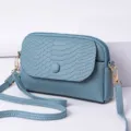 Blau-graue Mini-Umhängetasche für Damen mit strukturierter Klappe und goldener Hardware. - Schloss Blau