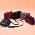 Detailed view of women's PU leather crossbody bag with floral embossing and metal decor. - Oak Red