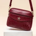 Women wine red leather crossbody shoulder bag with floral embossed design and metal flower charm. - Jujube Red