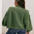 Green vintage knit cardigan detail showing stand collar, distressed seams, and lantern sleeves. - Green