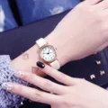 Nahaufnahme Detail der Damen Quarzuhr mit weißem Zifferblatt, Lederarmband und zarter Hand. - Numerische Skala / Weißes Armband Weißes Zifferblatt