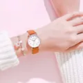 Detail shot of cute women leather strap watch on wrist with beaded bracelet in soft pink. - Brown