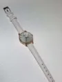 Detailansicht Uhr mit weißem Lederarmband, Roségold-Lünette und minimalistischem Zifferblatt. - Weiß
