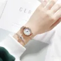 Detailaufnahme einer minimalistischen Damenuhr in Roségold mit Mesharmband und Armband. - Roségold-Armband römische Ziffern weißes Zifferblatt