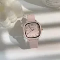 Detailaufnahme einer minimalistischen rosafarbenen quadratischen Damenuhr mit Lederarmband. - Rosa