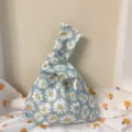 Japanische Stoff Knoten Handtasche Detail Ansicht mit Gänseblümchen Muster und Henkel. - Helles Gänseblümchen