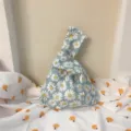 Detalle de bolso nudo de tela con margaritas azules, bonita bolsa de muñeca y monedero. - Bolso con Nudo de Estilo Japonés / Margarita Gris Azulado