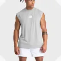 Détail de débardeur de sport gris en mesh, gros plan sur le tissu respirant sans manches. - Gris clair