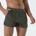 Pantaloncini sportivi in rete traspirante da uomo dettaglio, verde scuro con bordo blu e coulisse. - Taglia S / Verde oliva