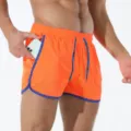 Vista dettagliata pantaloncini sportivi rete arancioni uomo con bordi e coulisse blu. - Arancione