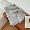 Grey knitted scarf for women featuring sweet black bow embroidery, soft and warm autumn winter accessory. - Gray
