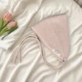 Vue detaillee d'un joli bonnet cagoule en tricot rose avec des liens et une petite etiquette. - Beige