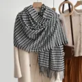 Detailopname van zwart-witte houndstooth sjaal met franjes, gezellige en warme winterstijl. - Zwart
