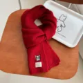 Detail van de rode gebreide wintershawl met schattige geborduurde hond, warme wollen halsdoek. - Rood