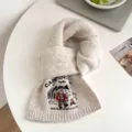 Cozy beige knit scarf featuring a cute camping bear embroidery and warm winter style details. - Almond White