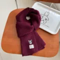 Close up of cozy winter wool knit scarf featuring cute embroidered dog patch and label detail. - Purple