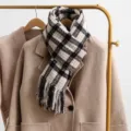 Klassieke vintage ruit wintershawl hangend aan rek, met zachte textuur en gezellige franjes. - Wit