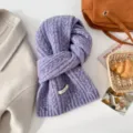 Detail shot of a cozy purple cable knit winter scarf, styled with elegant autumn accessories. - Purple
