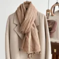 Detailed close-up of a cozy checkered linen scarf with cute tassels hanging gracefully. - Turmeric