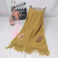 Detail shot of the solid mustard yellow cashmere-feel scarf with elegant fringe design. - Turmeric