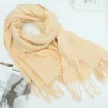 Gedetailleerd overzicht van gele ruit winter sjaal met zachte textuur en franjes. - Beige