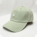 Close-up detail of sage green baseball cap featuring white 3d m embroidery and curved brim. - Adjustable / Light Green