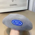 Detailed close-up of grey knitted beret featuring a blue rubber patch, soft texture style. - One Size / Gray