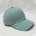 Close-up detail van de lichte blauwgroene honkbalpet met een schattig smiley-gezichtsetiket. - Verstelbaar / Haze Blauw