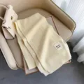 Sciarpa invernale in pura lana lavorata a maglia beige, accessorio caldo da donna. - Crema