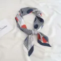 Detailed shot of a printed silk-feel skinny scarf with paisley and houndstooth patterns. - White Large Polka Dot
