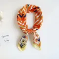 Close-up detail of geometric printed silk square scarf, vibrant orange and blue colorways. - Orange Striped