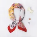 Gedetailleerd uitzicht op een zijden sjaal met een opvallende rode rand en bloemen. - Olieverfschilderij met rode rand